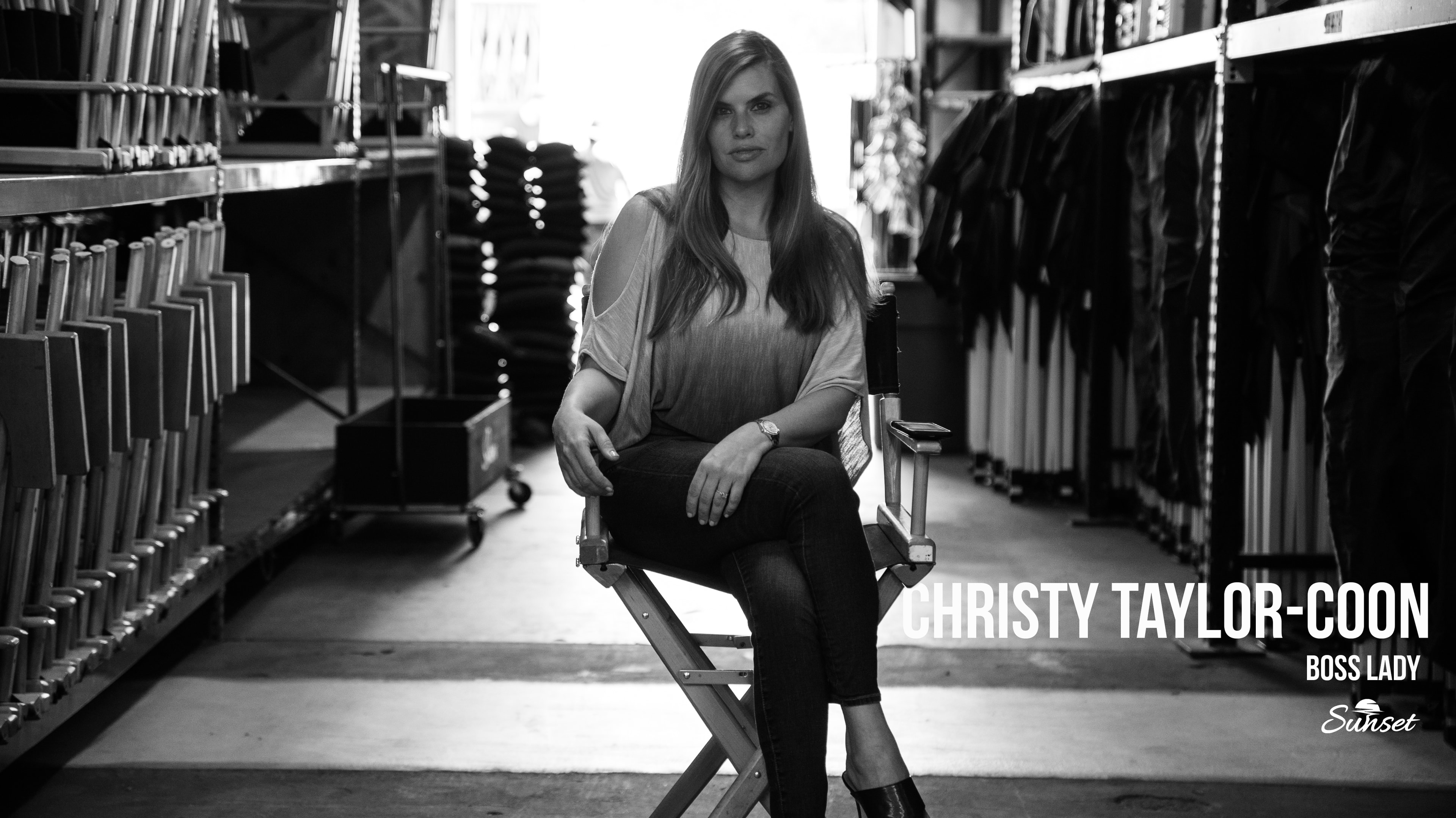 Christy Taylor-Coon, CEO, seated in a director's chair inside the Sunset warehouse
