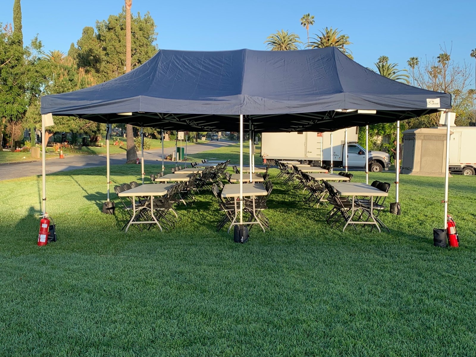 Sunset navy lunch tent with tables and chairs on a green lawn