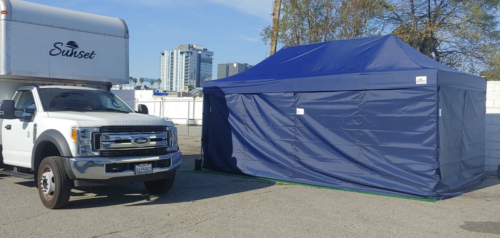 Sunset cube truck parked beside a blue changing tent on location