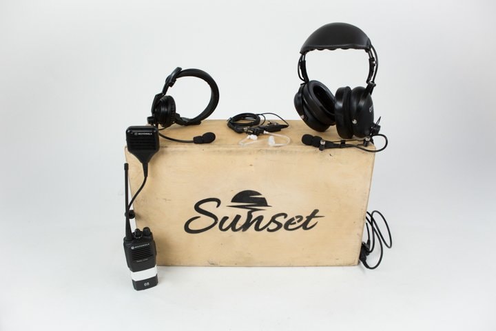 Motorola walkie, headsets and earpieces displayed on a vintage Sunset box